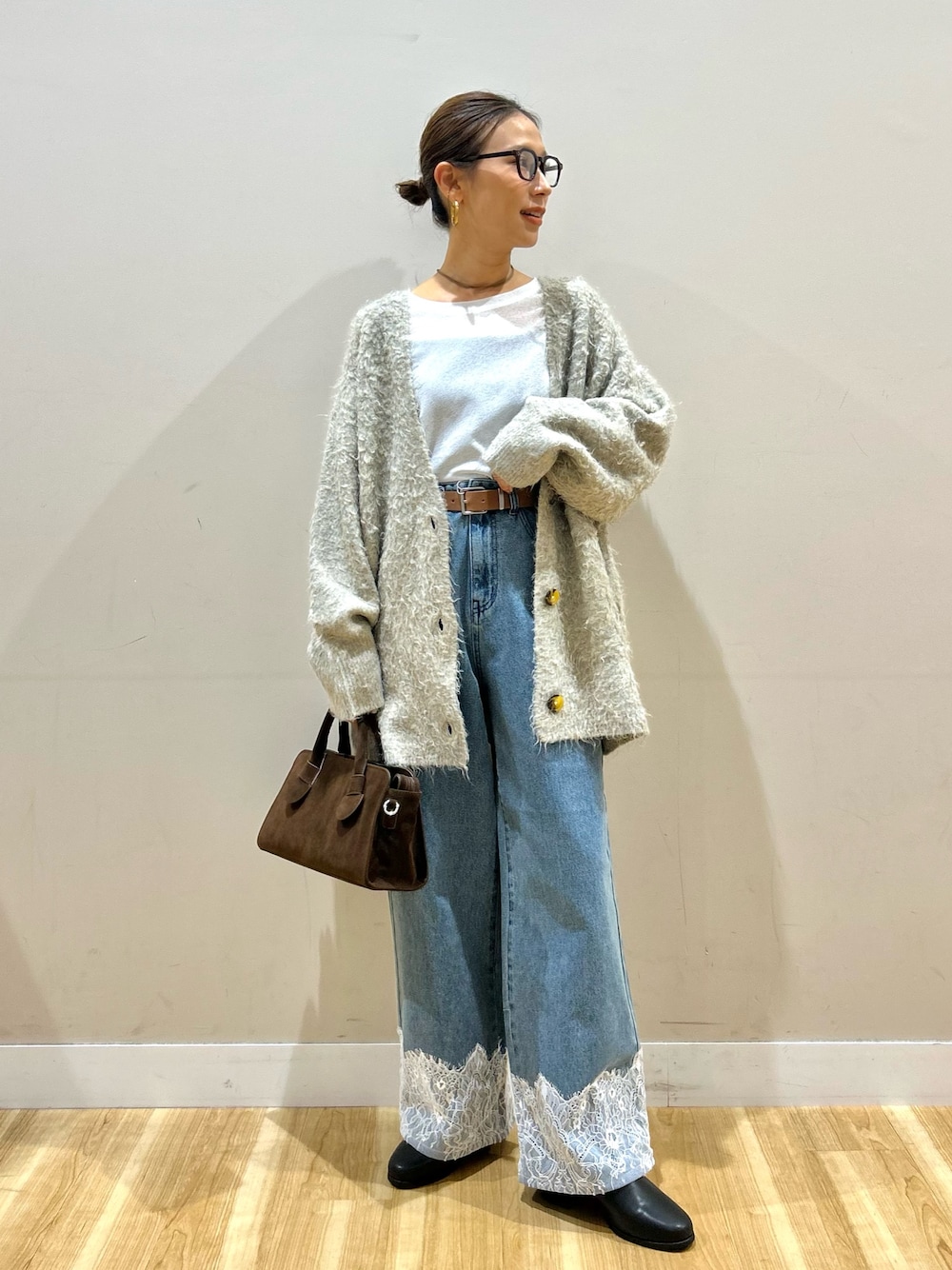 グレー系のカーディガン/ボレロ、ホワイト系のTシャツ/カットソー、ブルー系のデニムパンツを着用したレディースの秋コーディネートの1枚目の写真
