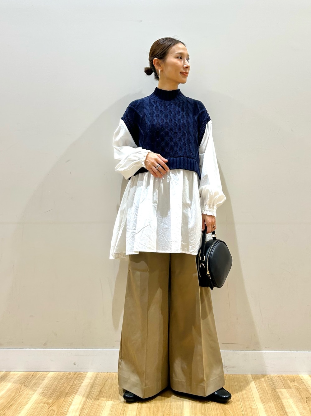 ホワイト系のシャツ/ブラウス、ベージュ系のチノパンツ、ブラック系のショルダーバッグを着用したレディースの秋コーディネートの1枚目の写真