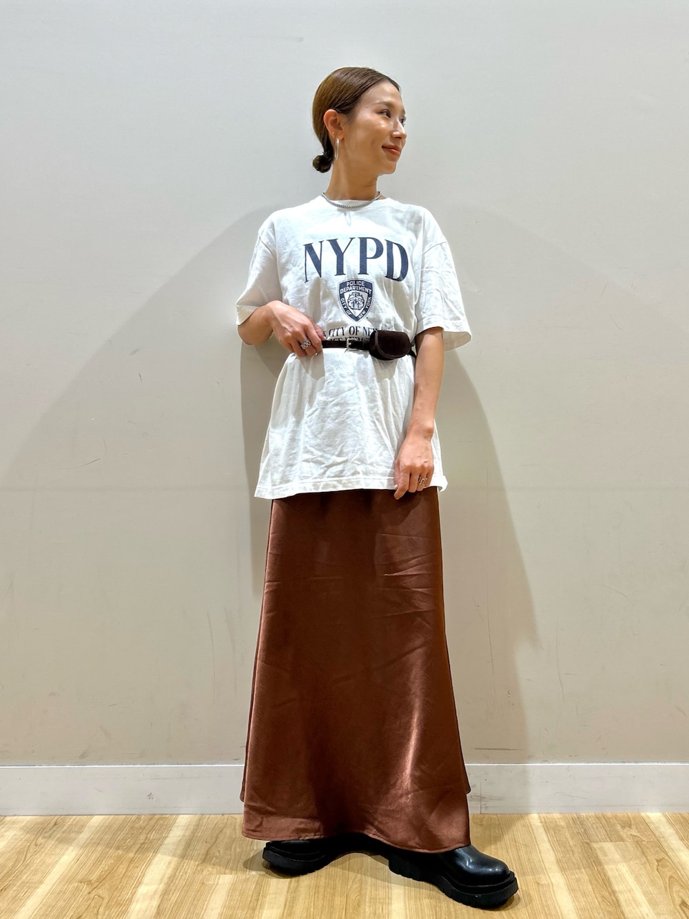 ホワイト系のTシャツ/カットソー、ブラウン系のスカート、ブラック系のブーツを着用したレディースの夏コーディネートの1枚目の写真