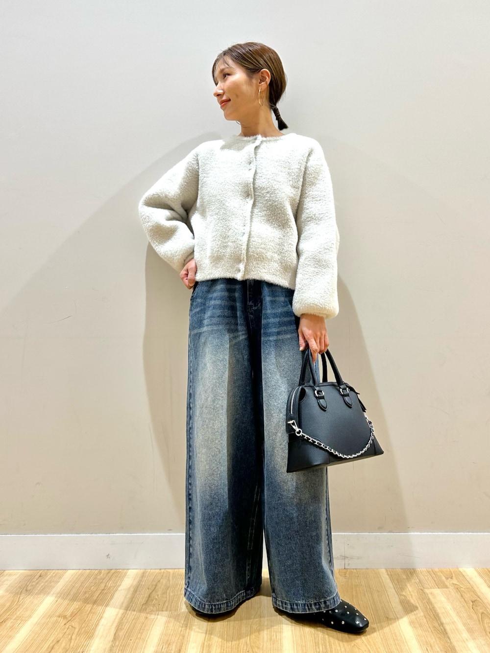 ホワイト系のカーディガン/ボレロ、ブルー系のデニムパンツを着用したレディースの冬コーディネートの1枚目の写真