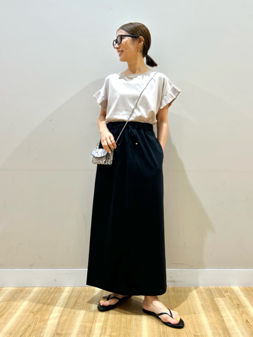 ベージュ系のTシャツ/カットソー、ブラック系のスカート、その他のショルダーバッグを着用したレディースの夏コーディネートの1枚目の写真