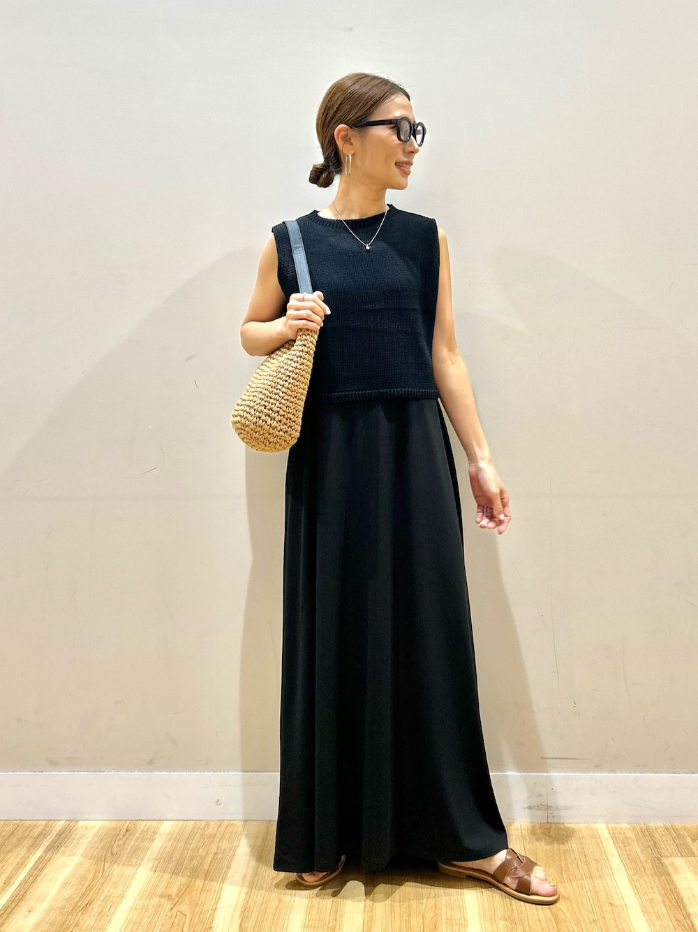 ブラック系のワンピース、ブラウン系のサンダル、ブラウン系のメガネを着用したレディースの夏コーディネートの1枚目の写真