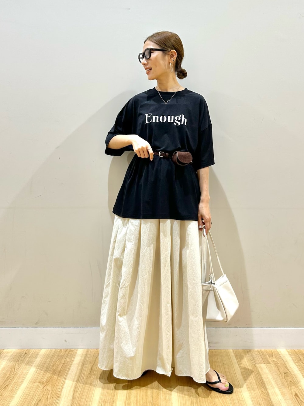 ブラック系のTシャツ/カットソー、ホワイト系のスカート、ホワイト系のハンドバッグを着用したレディースの夏コーディネートの1枚目の写真