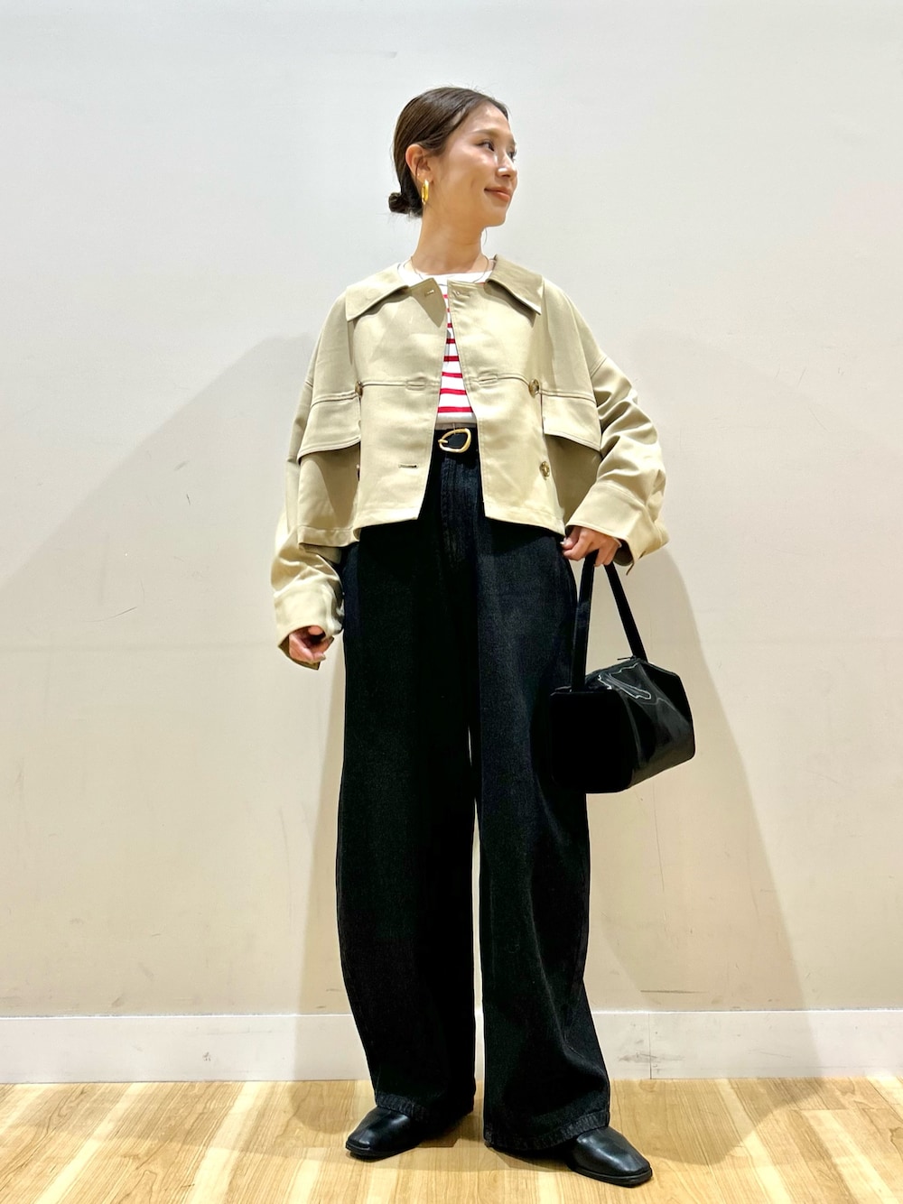 ベージュ系のその他アウター、レッド系のTシャツ/カットソー、ブラック系のデニムパンツを着用したレディースの春コーディネートの1枚目の写真