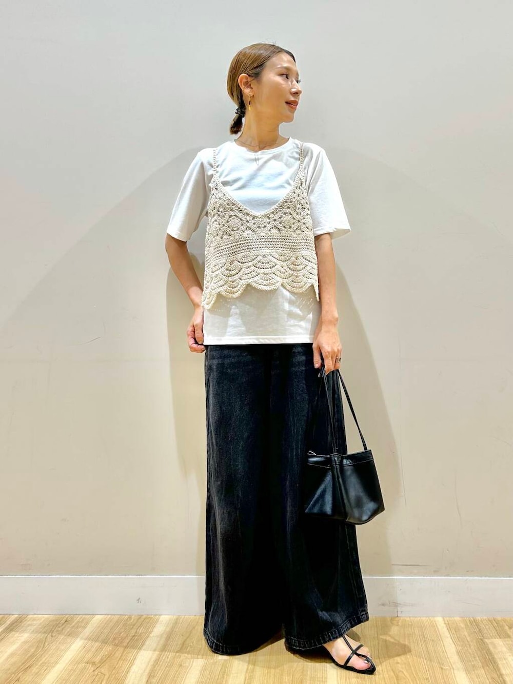ブラック系のデニムパンツ、ベージュ系のTシャツ/カットソーを着用したレディースの夏コーディネートの1枚目の写真