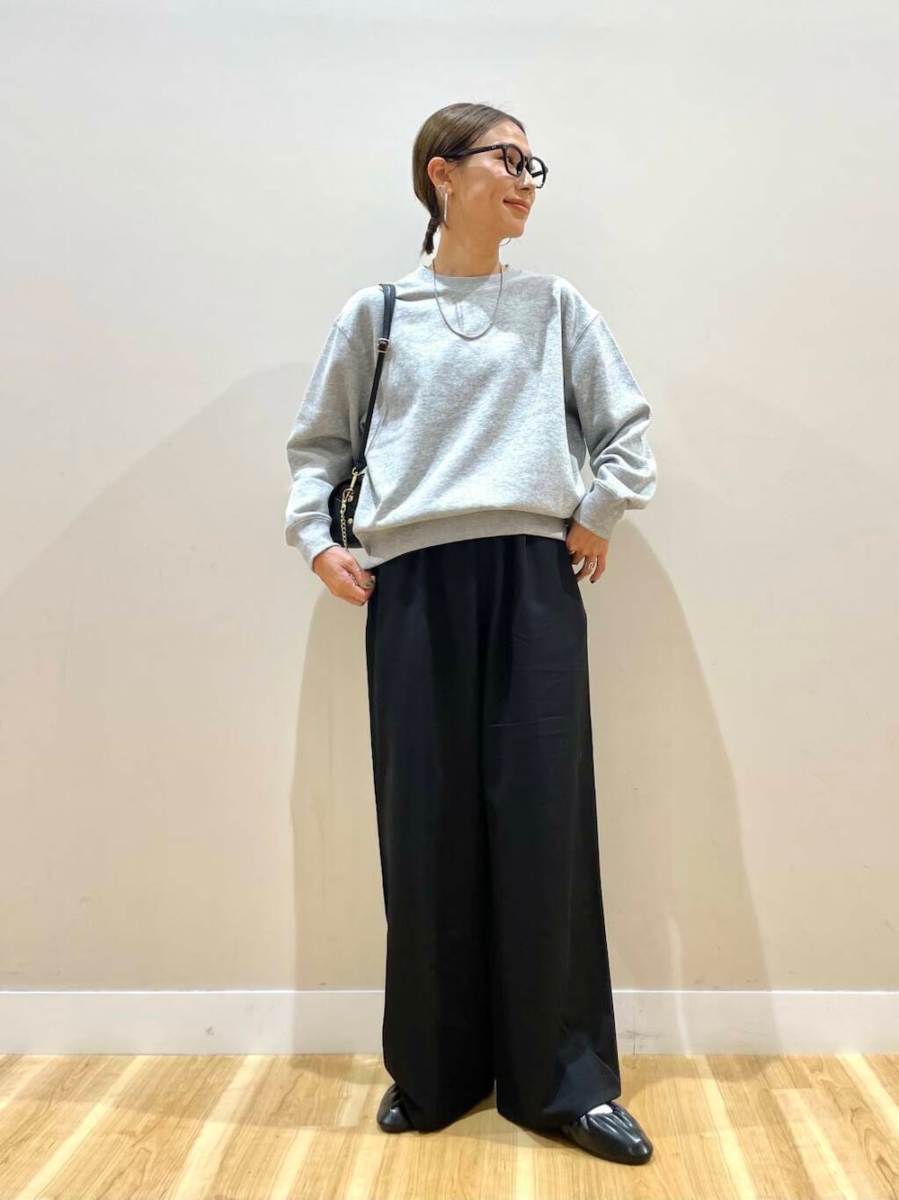 ブラック系のショルダーバッグ、ブラック系のバレエシューズ、グレー系のスウェットを着用したレディースの秋コーディネートの1枚目の写真