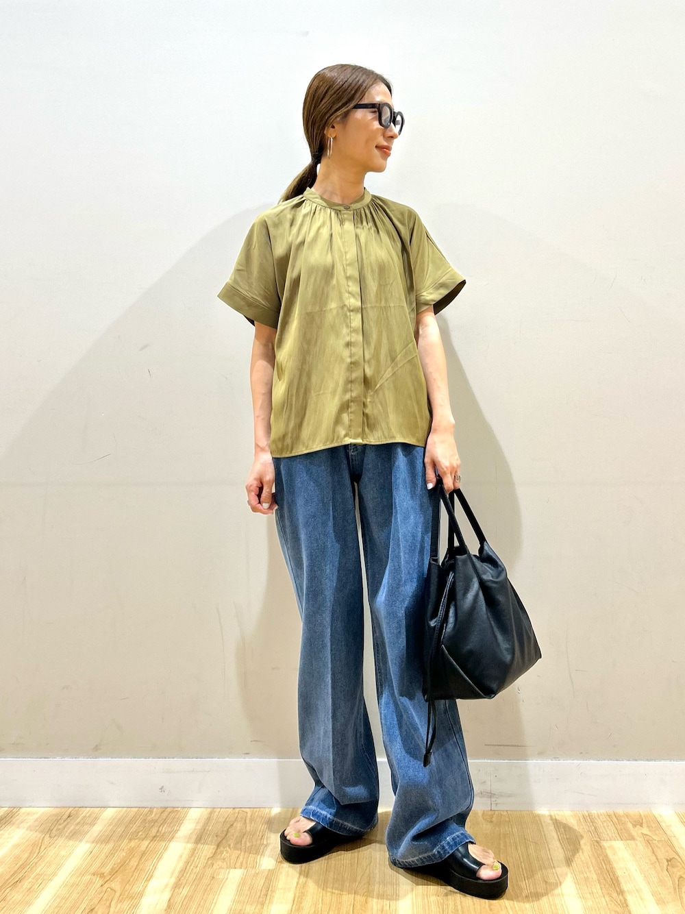 イエロー系のシャツ/ブラウス、ブルー系のデニムパンツ、ブラック系のショルダーバッグを着用したレディースの夏コーディネートの1枚目の写真