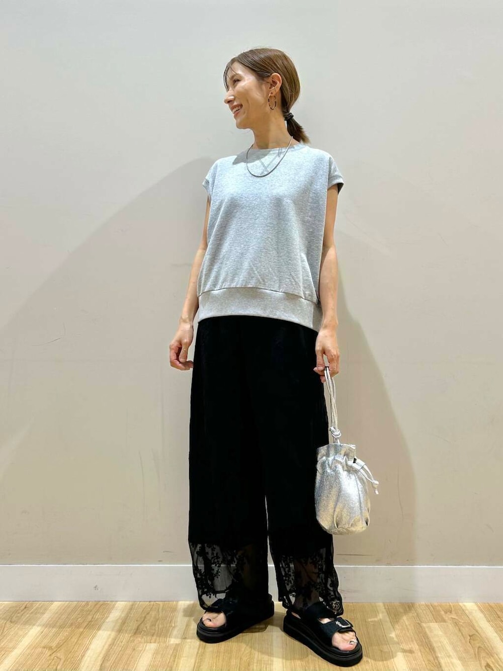 シルバー系のショルダーバッグ、ブラック系のその他パンツ、グレー系のベストを着用したレディースの夏コーディネートの1枚目の写真