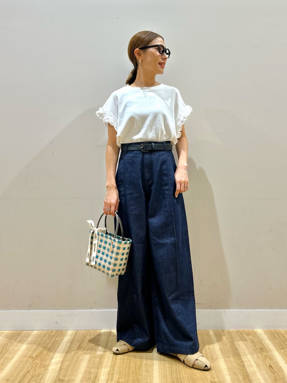 ホワイト系のTシャツ/カットソー、ブルー系のデニムパンツ、グリーン系のショルダーバッグを着用したレディースの夏コーディネートの1枚目の写真
