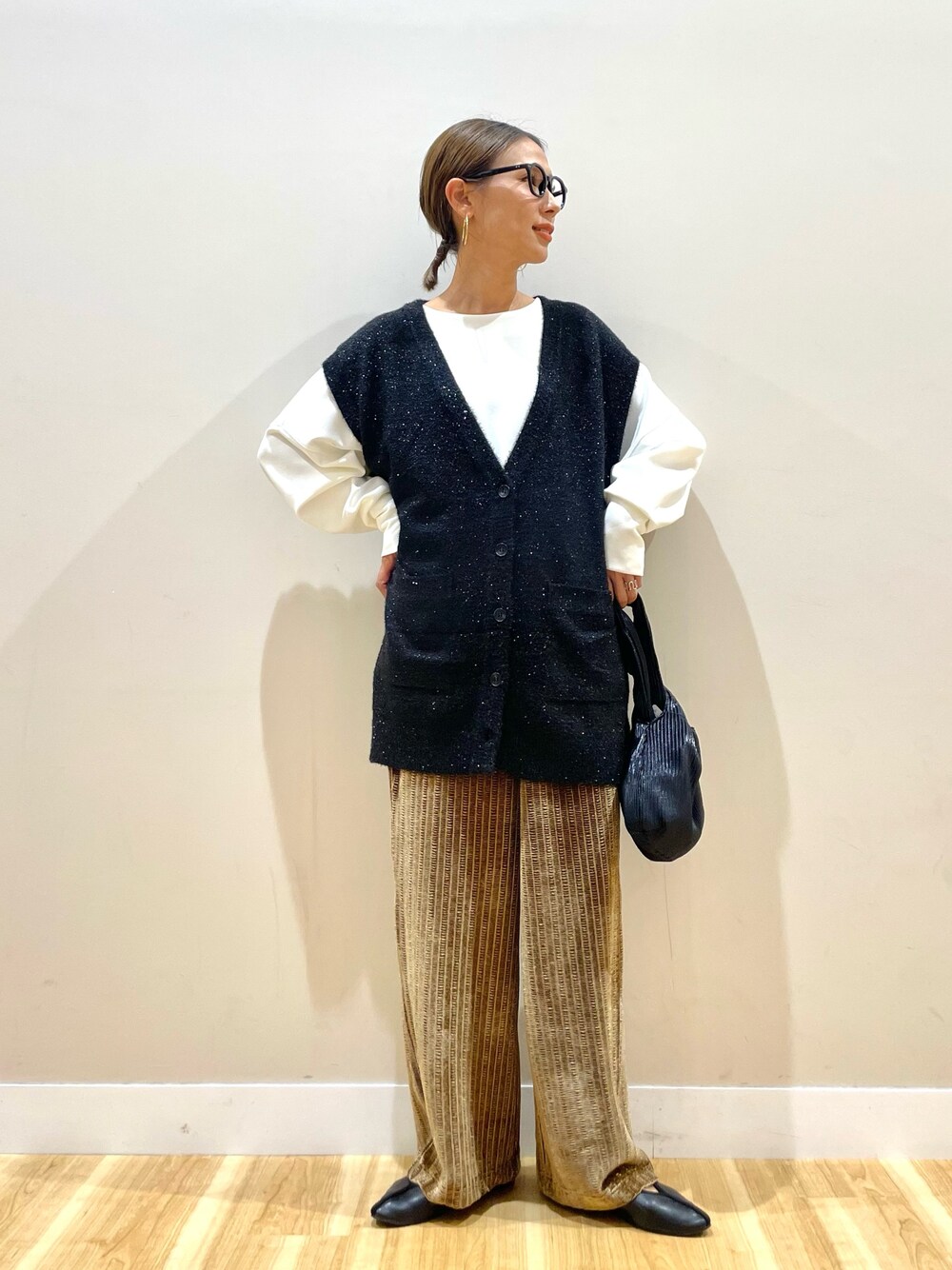 ブラック系のベスト、ホワイト系のTシャツ/カットソー、ブラウン系のその他パンツを着用したレディースの秋コーディネートの1枚目の写真