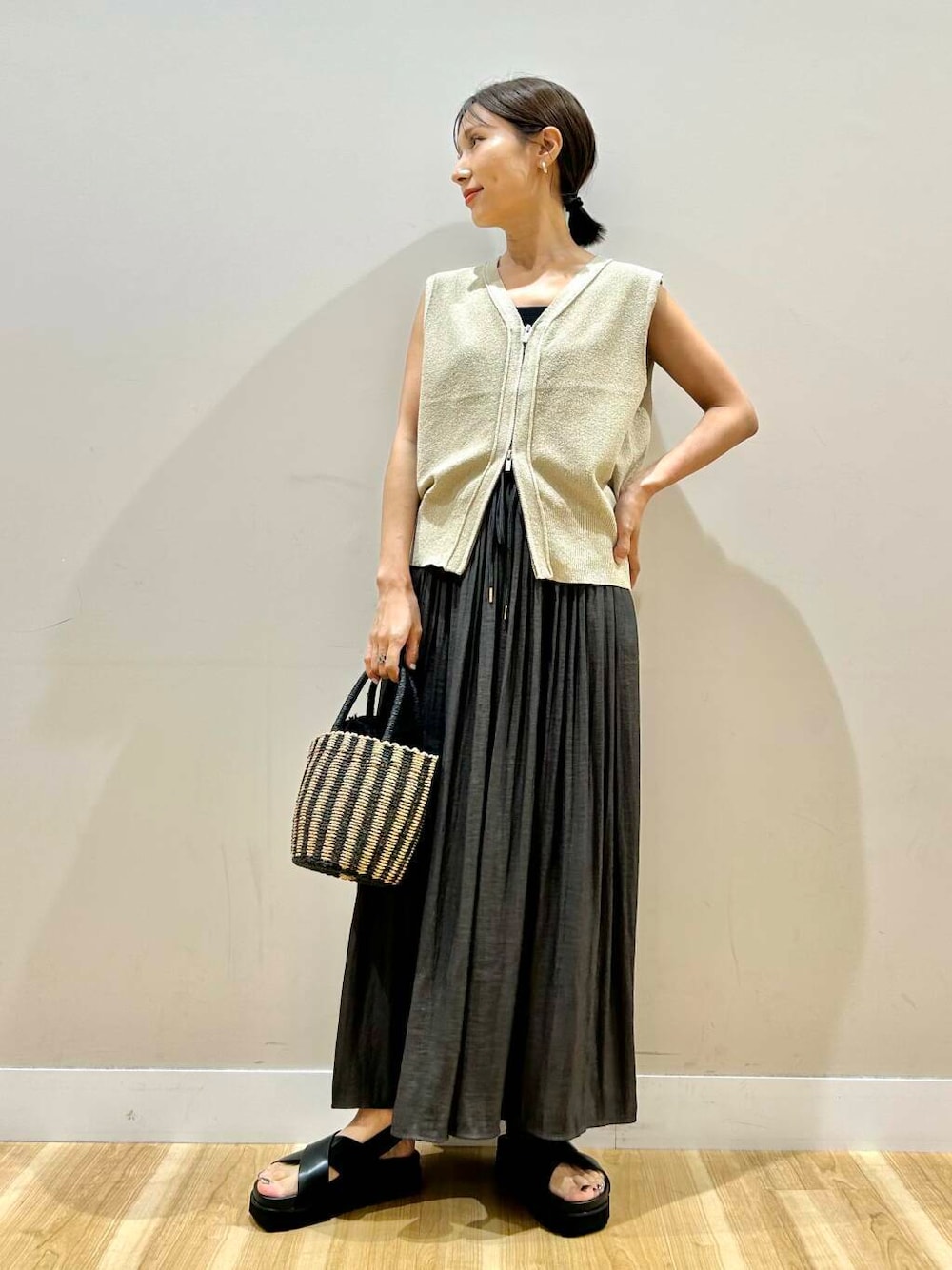 ブラック系のハンドバッグ、グレー系のその他パンツ、ブラック系のサンダルを着用したレディースの夏コーディネートの1枚目の写真