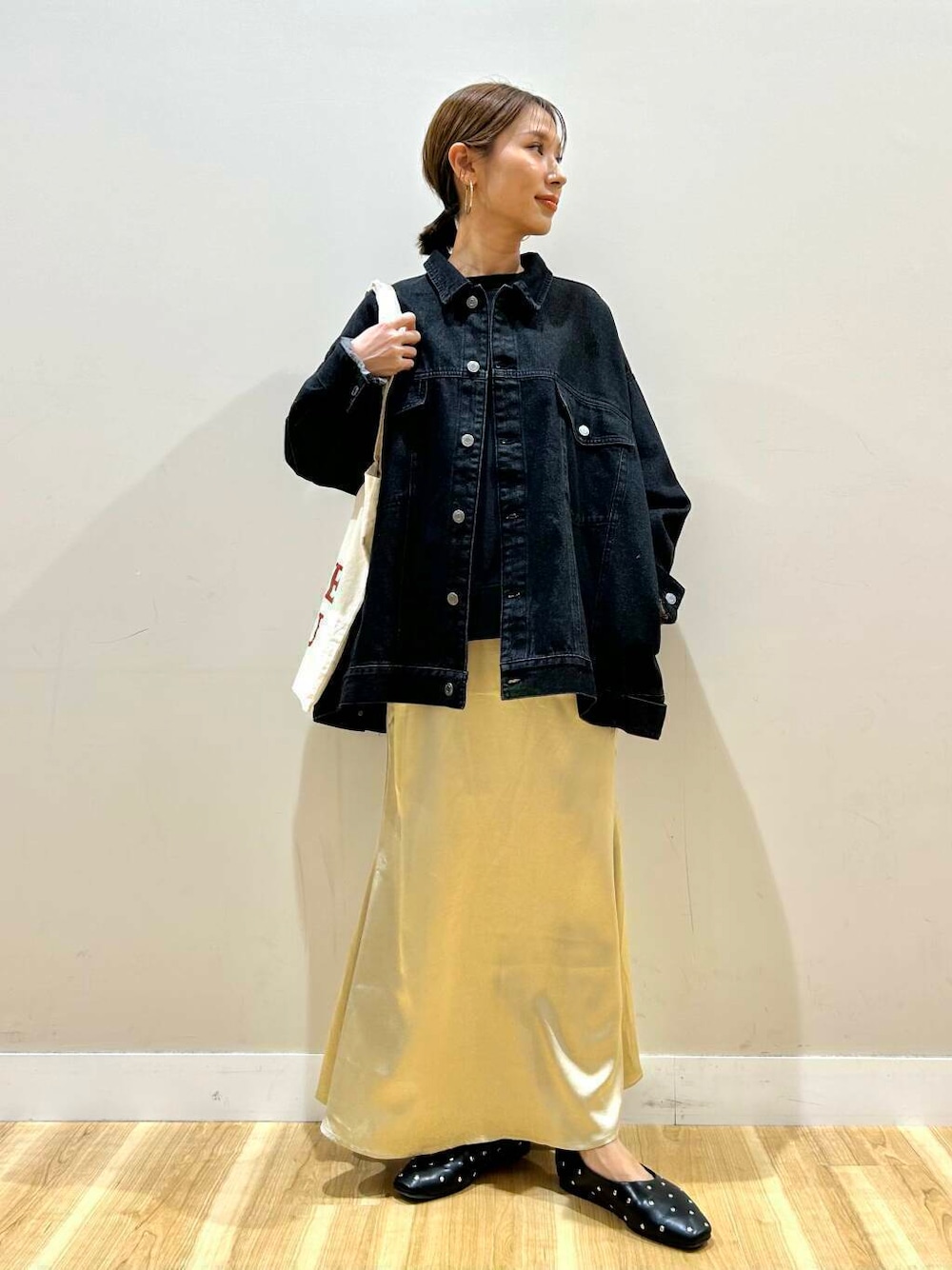 ブラック系のパンプス、ホワイト系のトートバッグ、ブラック系のデニムジャケットを着用したレディースの冬コーディネートの1枚目の写真