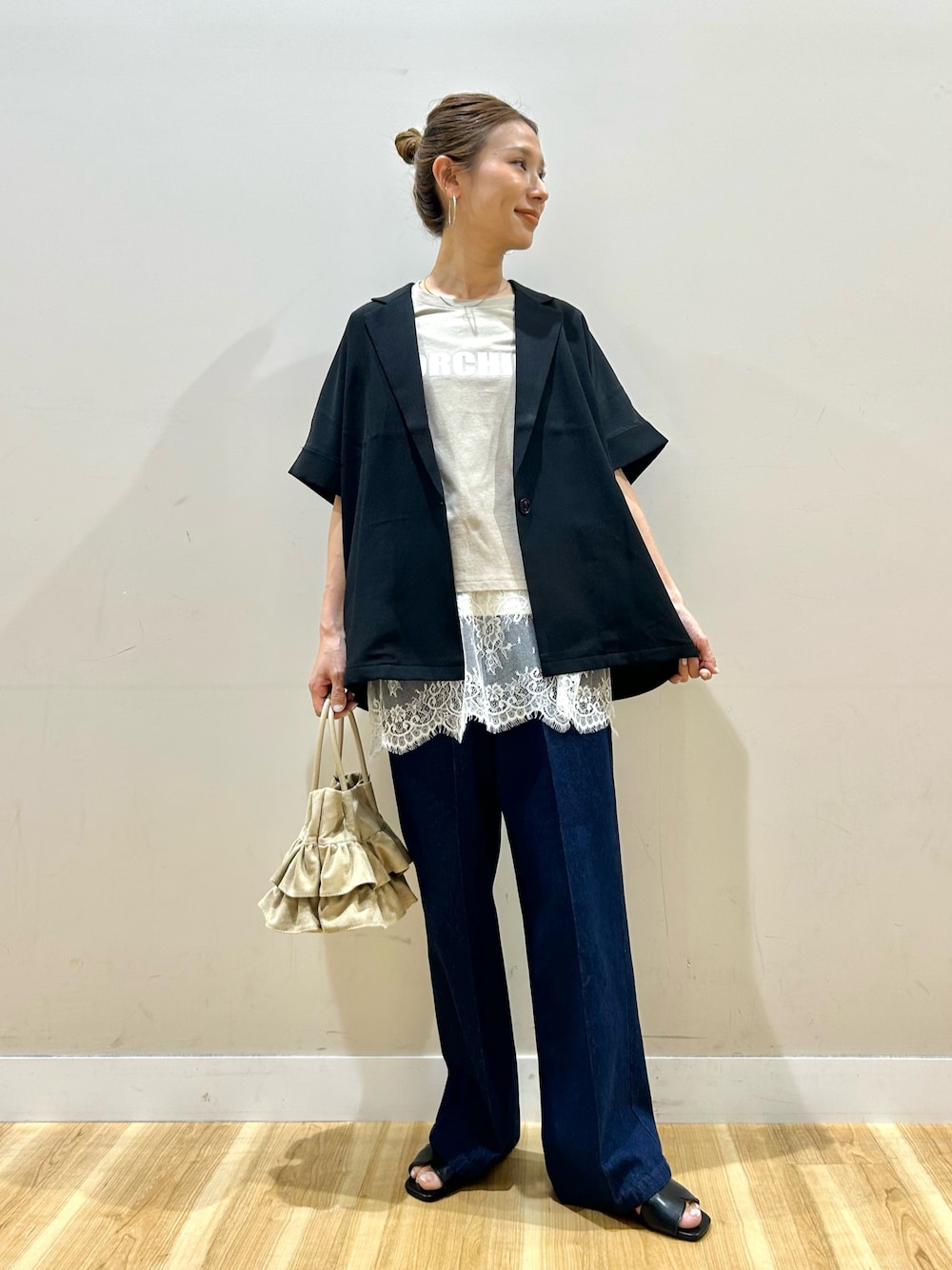 ブラック系のその他アウター、ベージュ系のTシャツ/カットソー、ブルー系のデニムパンツを着用したレディースの春コーディネートの1枚目の写真