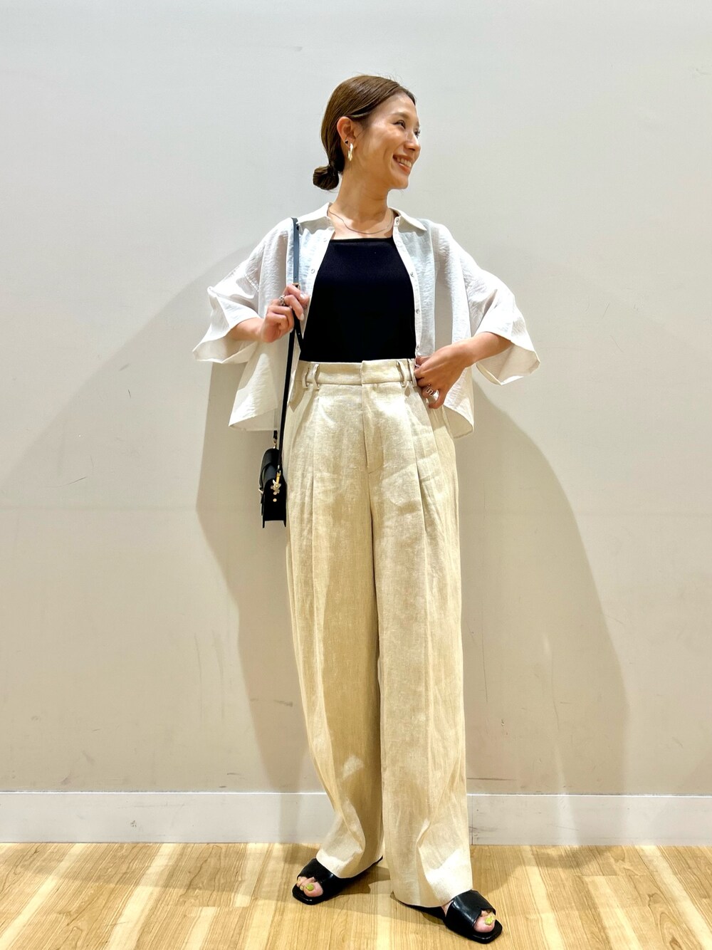 ホワイト系のシャツ/ブラウス、ベージュ系のその他パンツ、ブラック系のショルダーバッグを着用したレディースの夏コーディネートの1枚目の写真