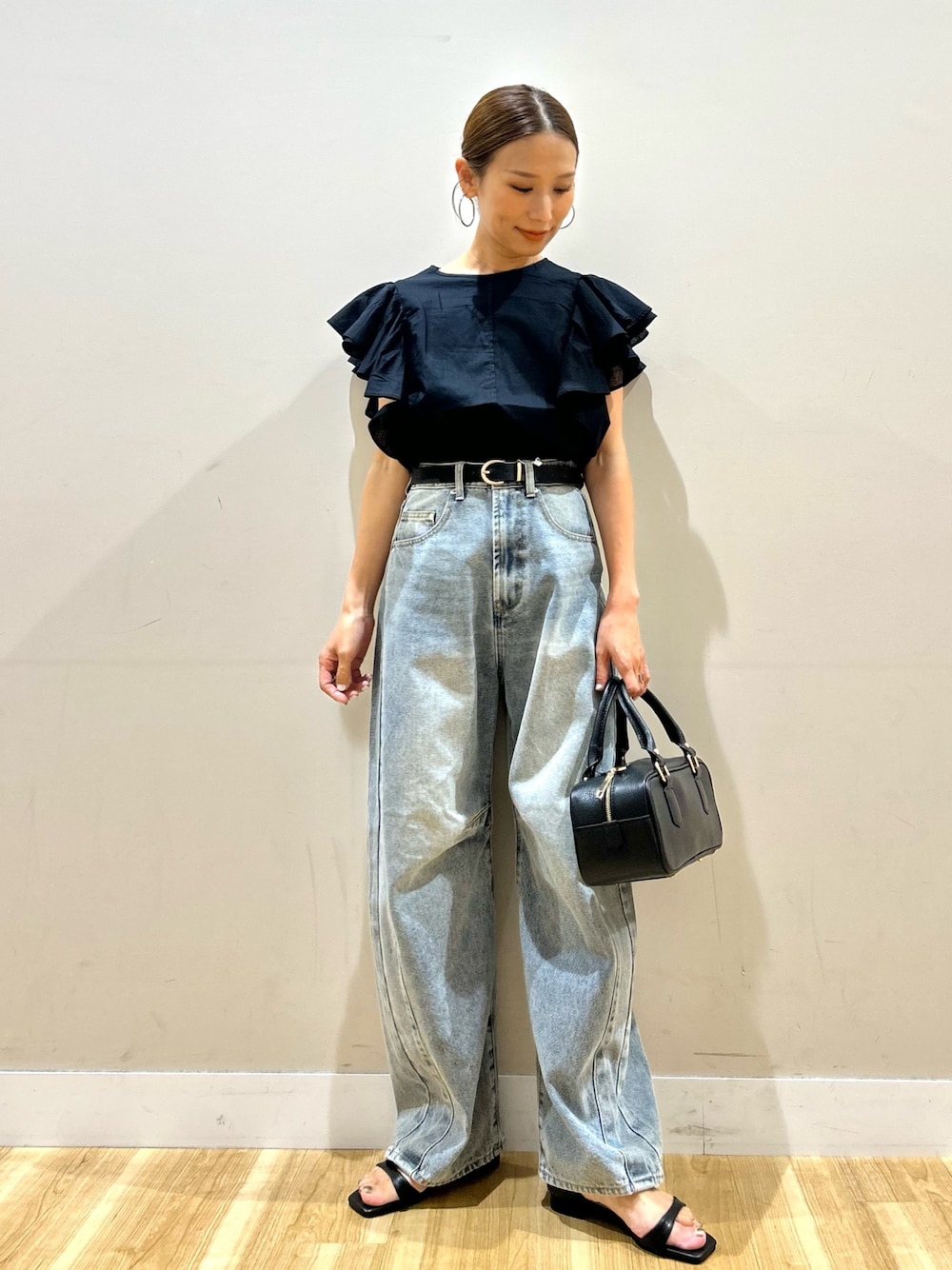 ブラック系のシャツ/ブラウス、ブルー系のデニムパンツ、ブラック系のサンダルを着用したレディースの夏コーディネートの1枚目の写真