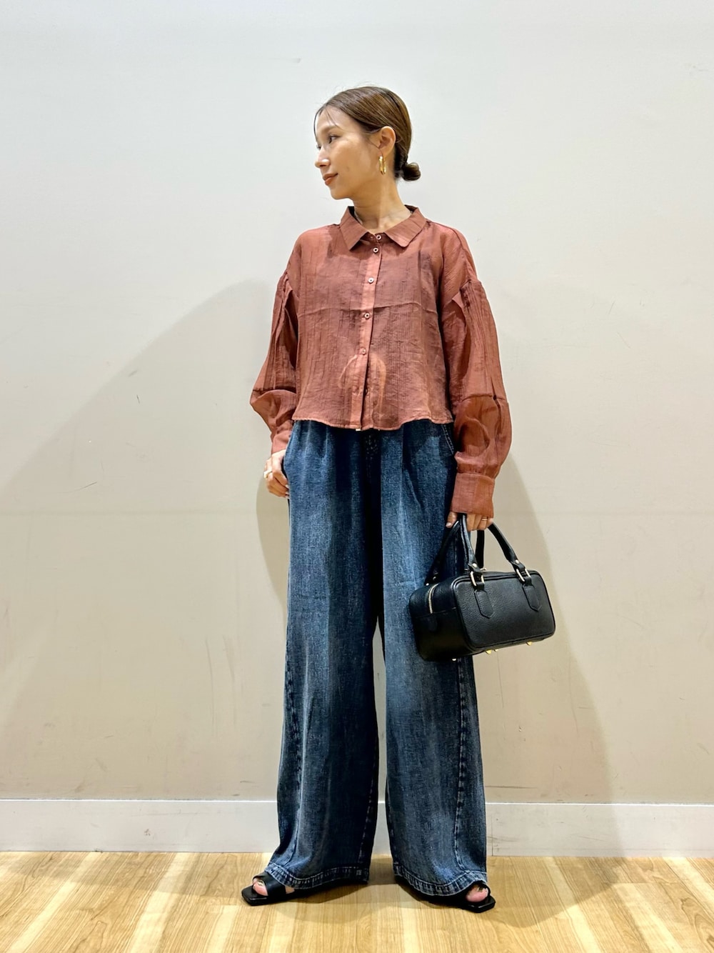 オレンジ系のシャツ/ブラウス、ブルー系のデニムパンツ、ブラック系のハンドバッグを着用したレディースの夏コーディネートの1枚目の写真