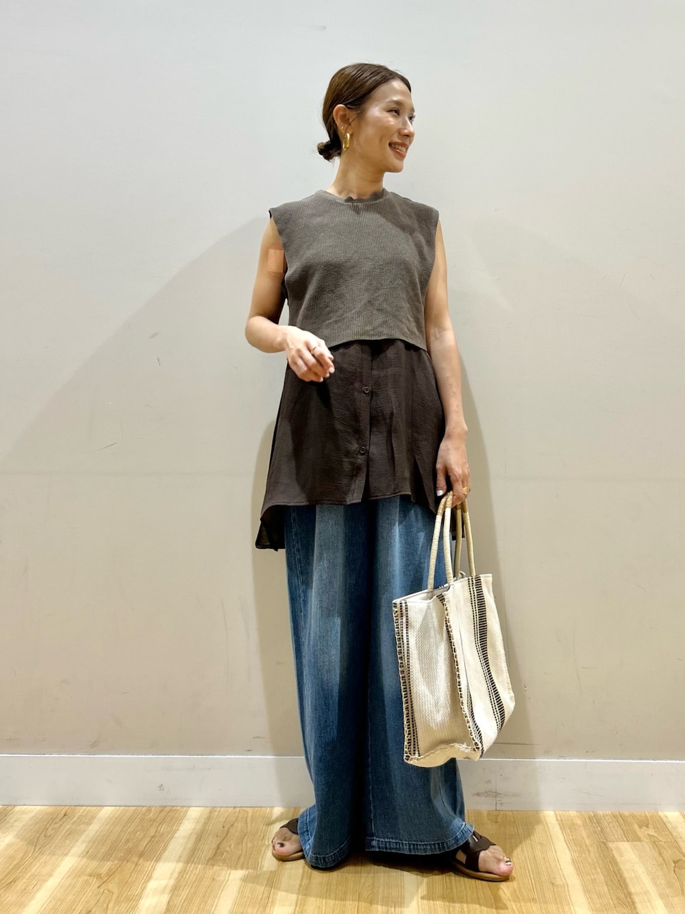 ブラウン系のシャツ/ブラウス、ブルー系のデニムパンツ、ホワイト系のトートバッグを着用したレディースの夏コーディネートの1枚目の写真