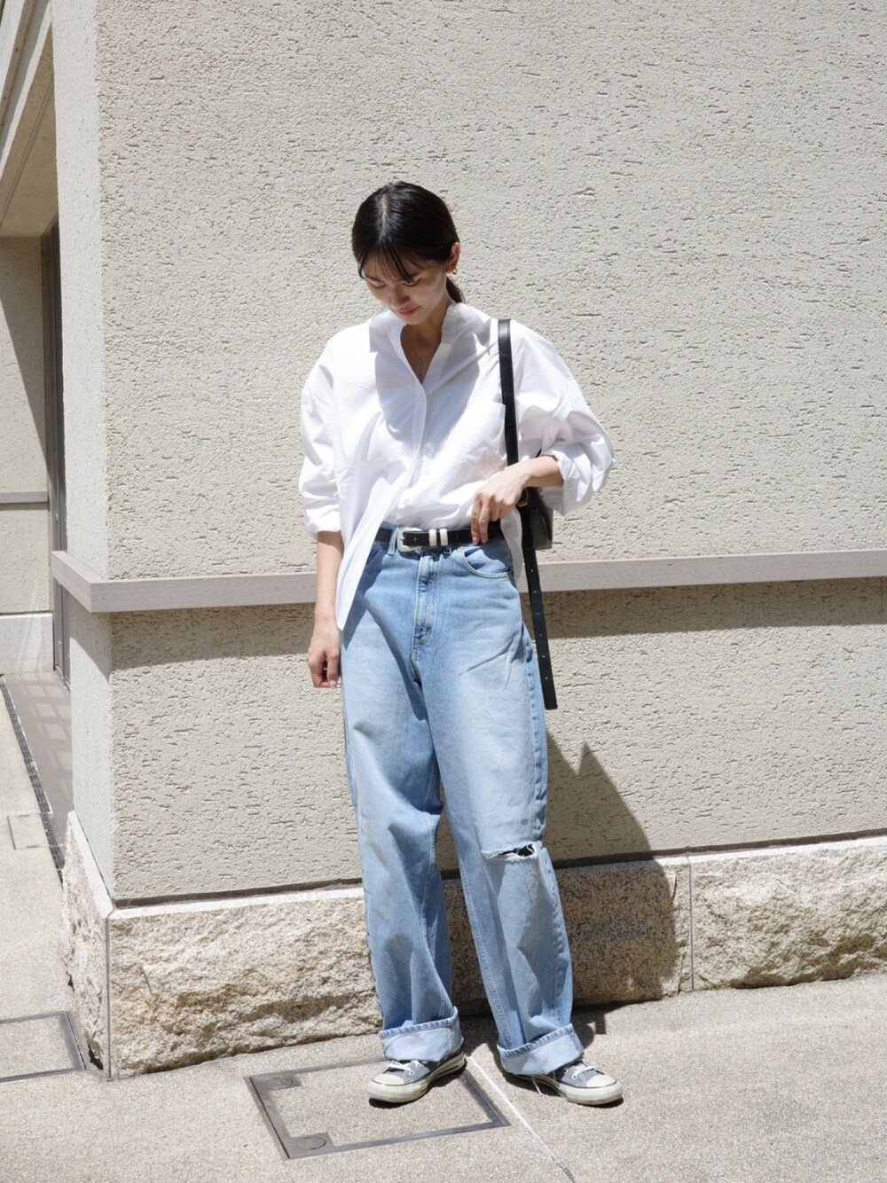 ブルー系のデニムパンツ、ホワイト系のシャツ/ブラウスを着用したレディースの春コーディネートの1枚目の写真
