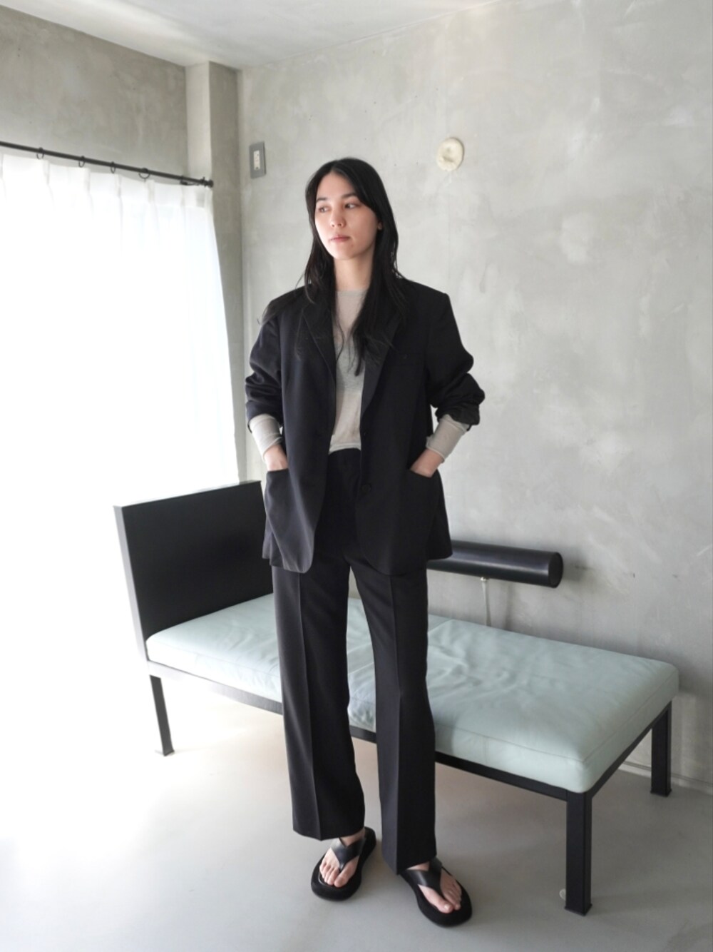 ブラック系のテーラードジャケット、グレー系のTシャツ/カットソー、ブラック系のスラックスを着用したレディースの春コーディネートの1枚目の写真