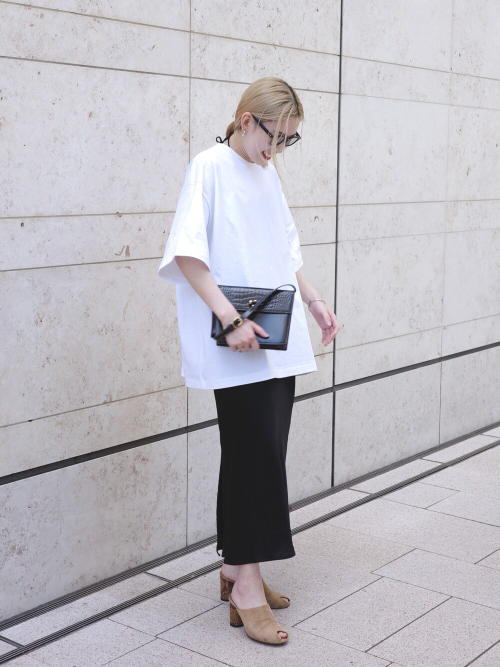 ホワイト系のTシャツ/カットソー、ブラック系のスカートを着用したレディースの夏コーディネートの1枚目の写真