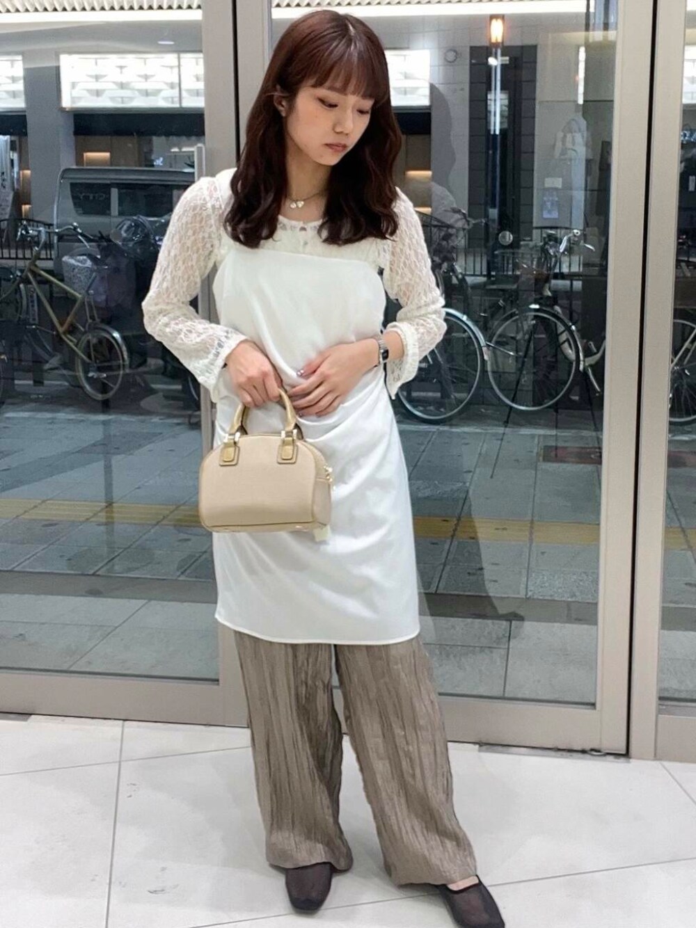 ベージュ系のボストンバッグ、ブラウン系のその他パンツ、ブラック系のバレエシューズを着用したレディースの春コーディネートの1枚目の写真