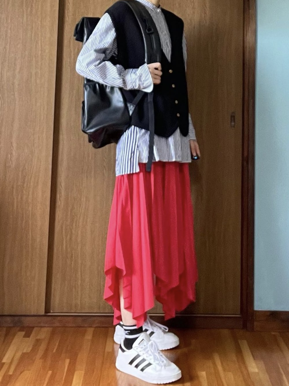 ブルー系のシャツ/ブラウス、レッド系のスカート、ブラック系のバックパック/リュックを着用したレディースの冬コーディネートの1枚目の写真