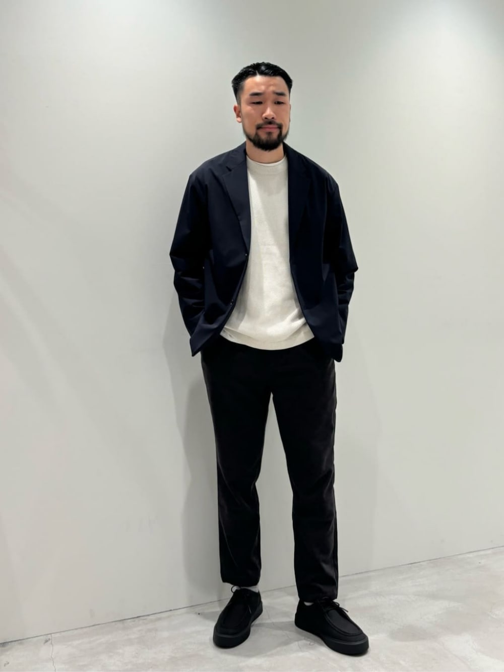 ブルー系のテーラードジャケット、ホワイト系のニット/セーター、グレー系のその他パンツを着用したメンズの秋コーディネートの1枚目の写真