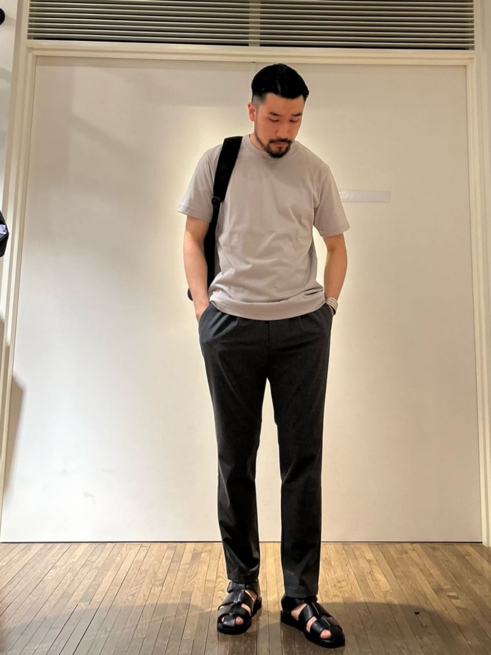 グレー系のその他パンツ、グレー系のTシャツ/カットソー、ブラック系のサンダルを着用したメンズの夏コーディネートの1枚目の写真