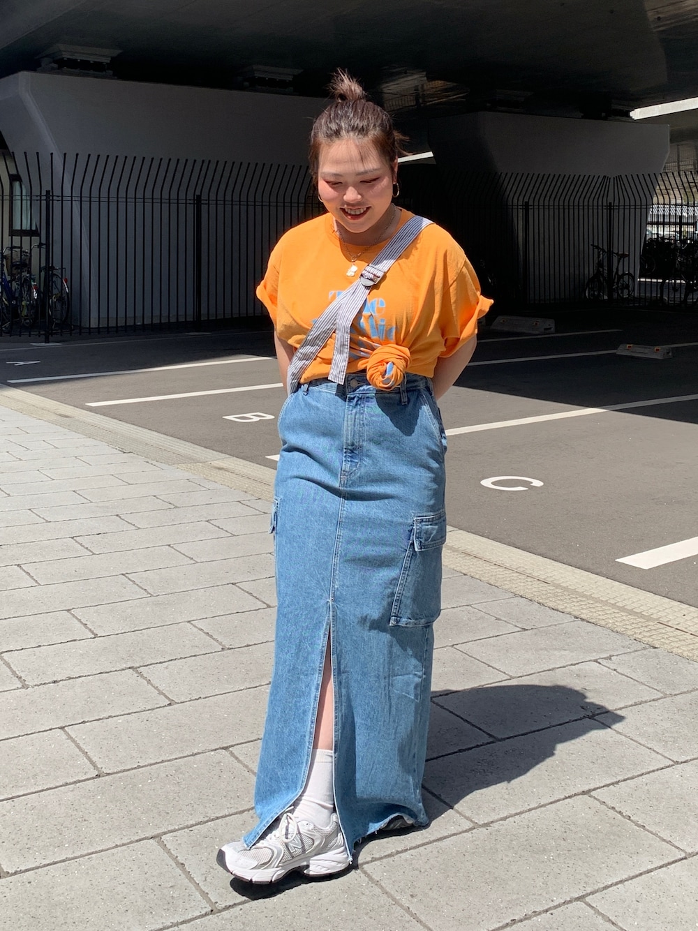 オレンジ系のTシャツ/カットソー、その他のショルダーバッグ、ブルー系のデニムスカートを着用したレディースの春コーディネートの1枚目の写真