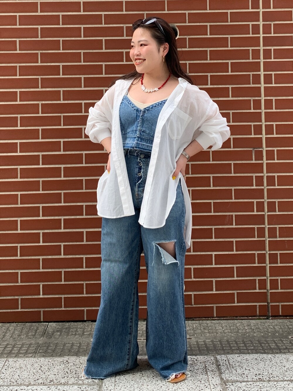 ブルー系のキャミソール、ホワイト系のシャツ/ブラウス、ブルー系のデニムパンツを着用したレディースの春コーディネートの1枚目の写真