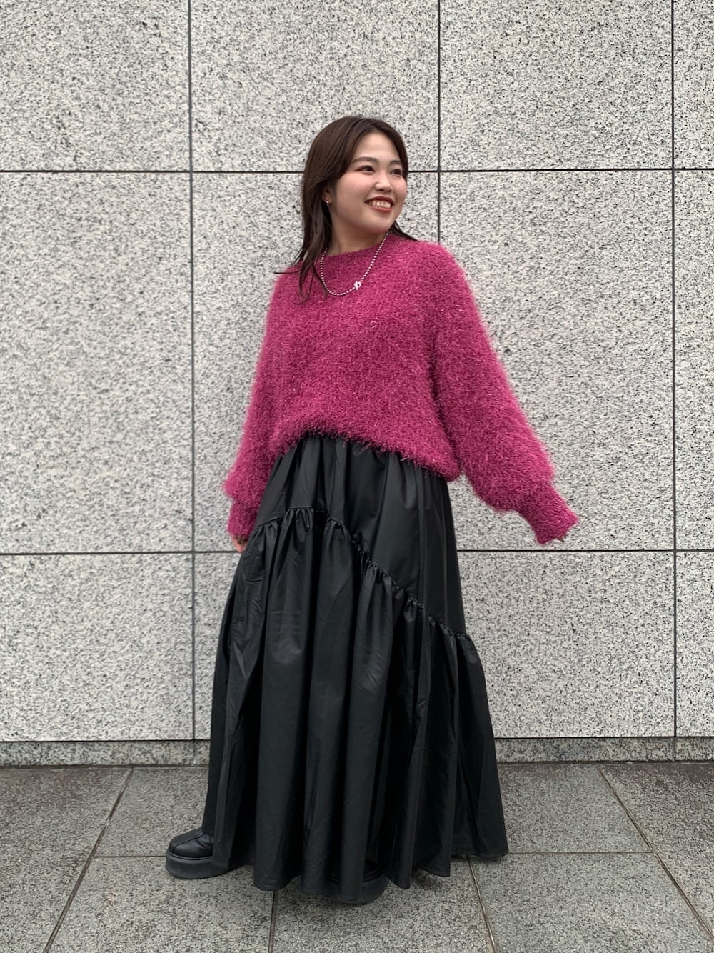 パープル系のニット/セーター、ブラック系のスカート、ブラック系のブーツを着用したレディースの秋コーディネートの1枚目の写真