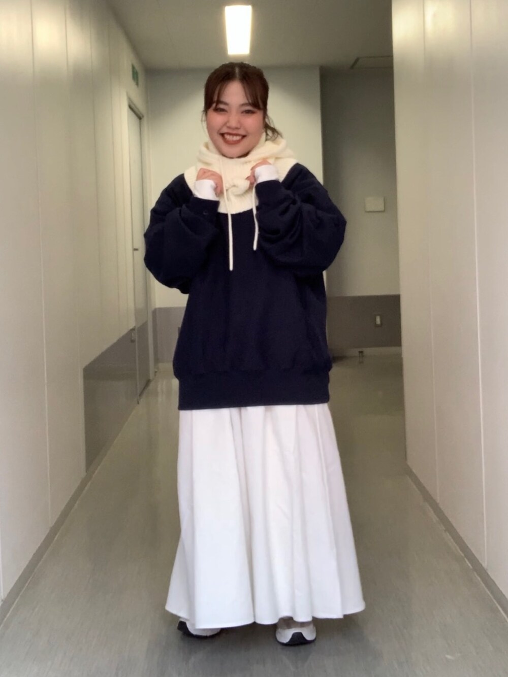 グレー系のワンピース、ブルー系のスウェット、ホワイト系のニットキャップ/ビーニーを着用したレディースの秋コーディネートの1枚目の写真