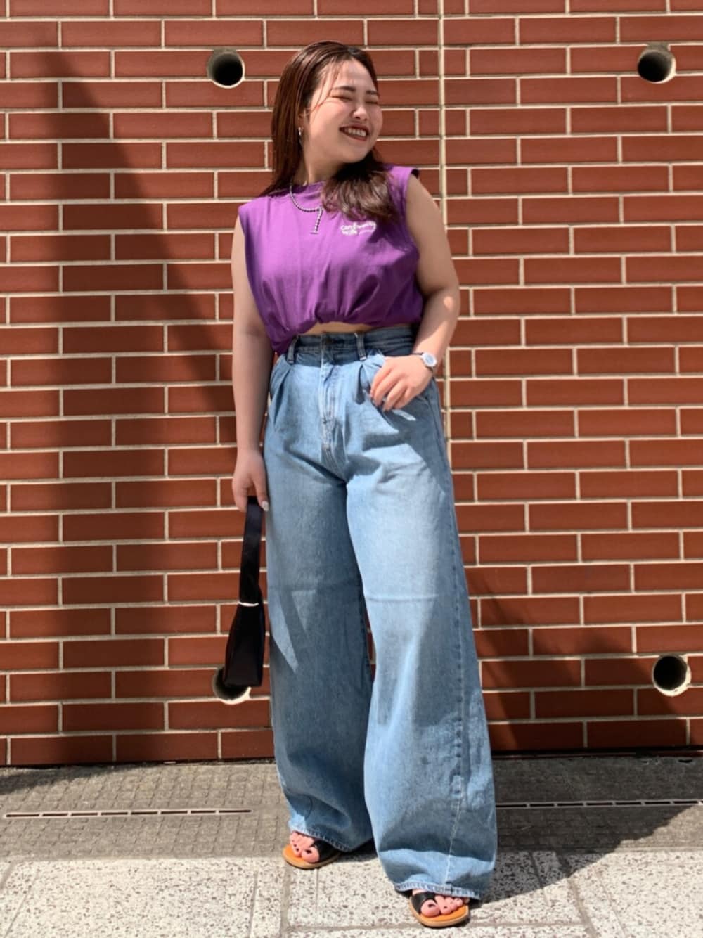 パープル系のタンクトップ、ブルー系のデニムパンツを着用したレディースの夏コーディネートの1枚目の写真