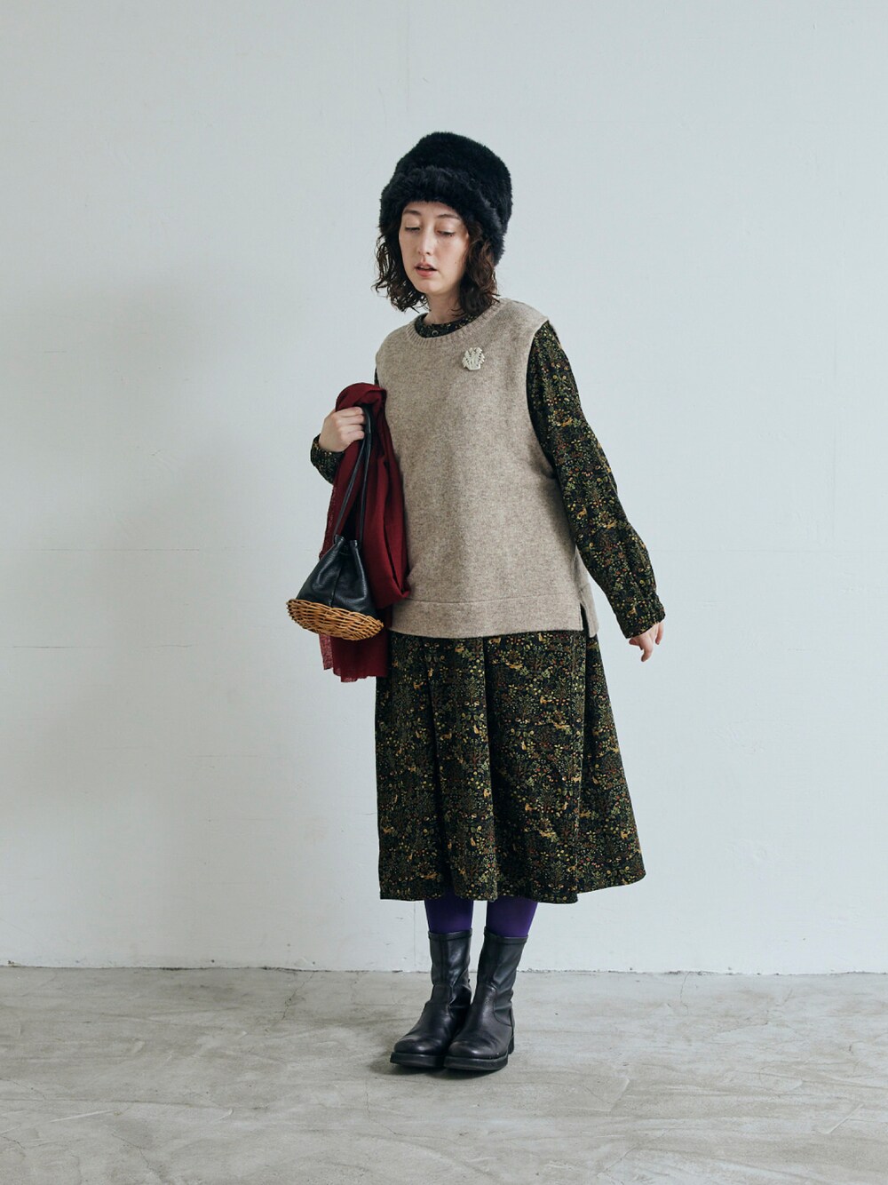 ブラック系のワンピース、ベージュ系のベストを着用したレディースの秋コーディネートの1枚目の写真