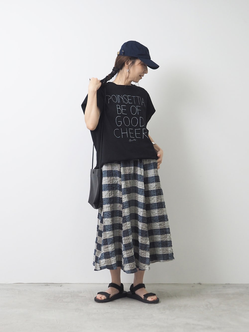 ベージュ系のスカート、ブラック系のTシャツ/カットソーを着用したレディースの夏コーディネートの1枚目の写真