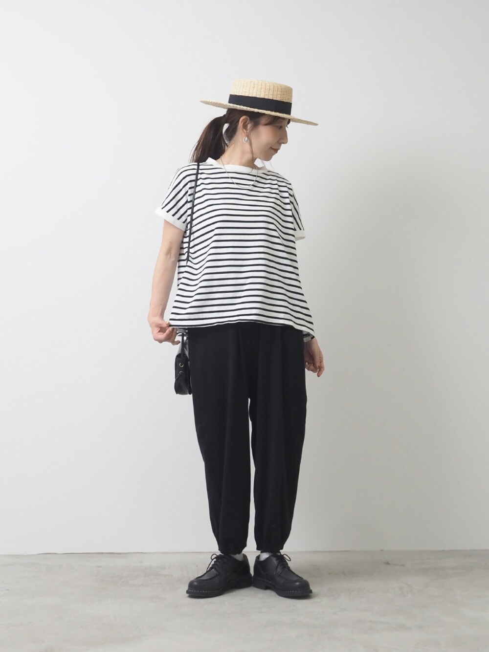 ホワイト系のTシャツ/カットソー、ブラック系のパンツを着用したレディースの夏コーディネートの1枚目の写真