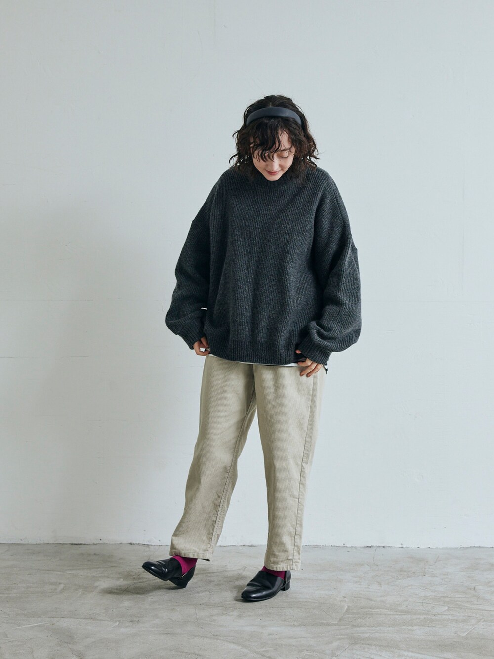 グレー系のニット/セーター、ベージュ系のパンツを着用したレディースの秋コーディネートの1枚目の写真