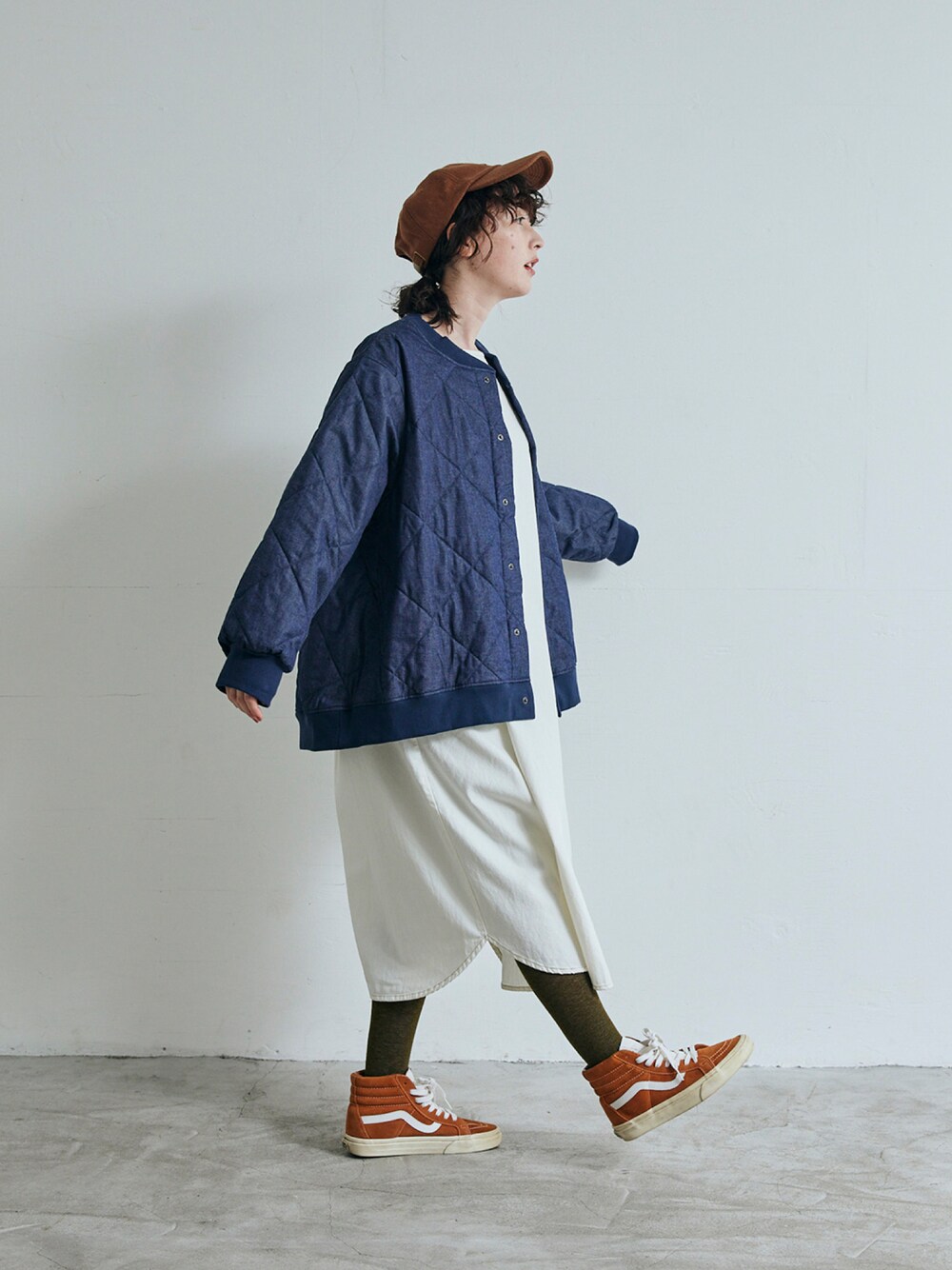 ブルー系のデニムジャケット、ホワイト系のワンピースを着用したレディースの秋コーディネートの1枚目の写真