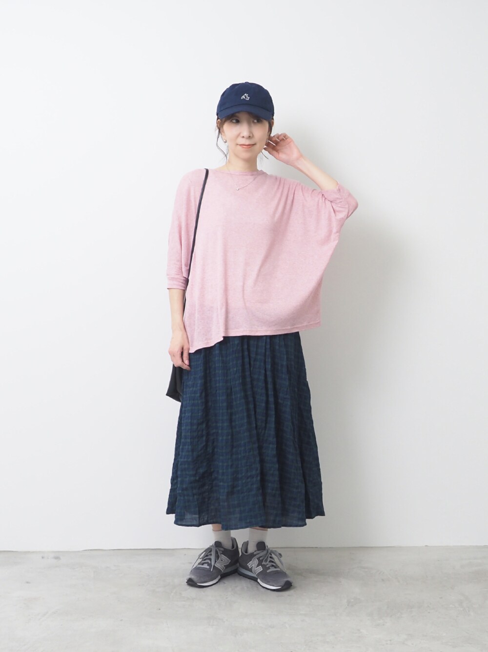 ピンク系のTシャツ/カットソー、ホワイト系のスカート、グレー系のスニーカーを着用したレディースの夏コーディネートの1枚目の写真