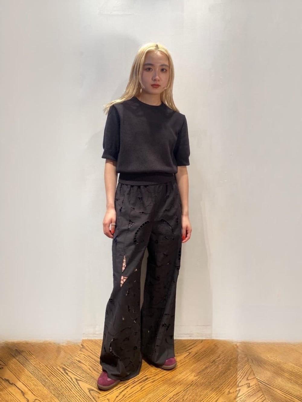 レッド系のスニーカー、グレー系のニット/セーター、ブラック系のその他パンツを着用したレディースの夏コーディネートの1枚目の写真