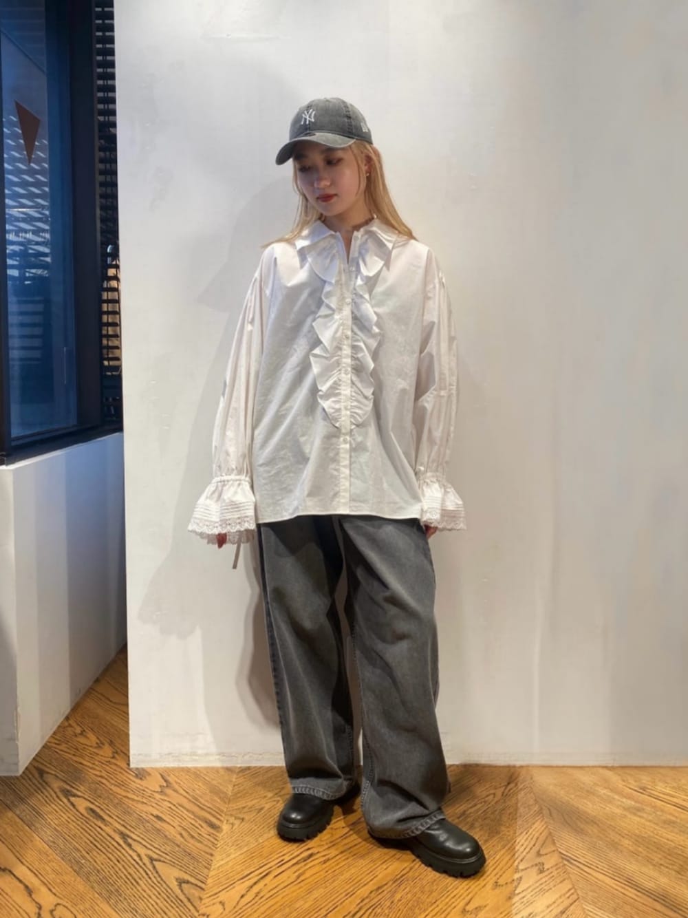 ホワイト系のシャツ/ブラウス、ブラック系のデニムパンツ、ブラック系のブーツを着用したレディースの春コーディネートの1枚目の写真