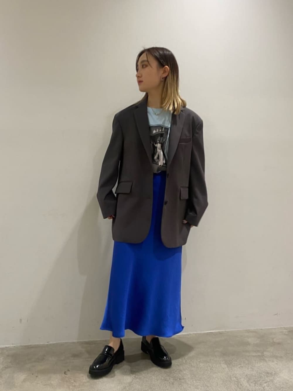 ブラック系のローファー、ブルー系のTシャツ/カットソー、ブルー系のスカートを着用したレディースの春コーディネートの1枚目の写真