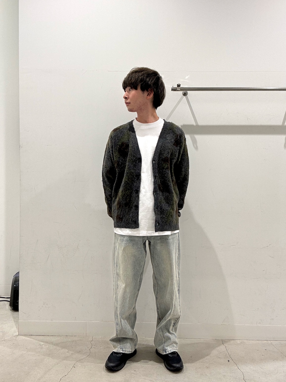 グリーン系のニット/セーター、ホワイト系のTシャツ/カットソー、ブルー系のデニムパンツを着用したメンズの秋コーディネートの1枚目の写真