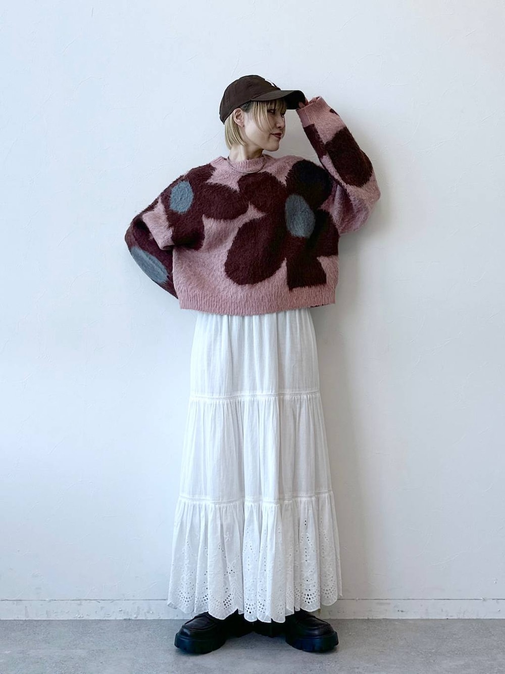 ブラック系のローファー、ピンク系のニット/セーター、ホワイト系のスカートを着用したレディースの秋コーディネートの1枚目の写真