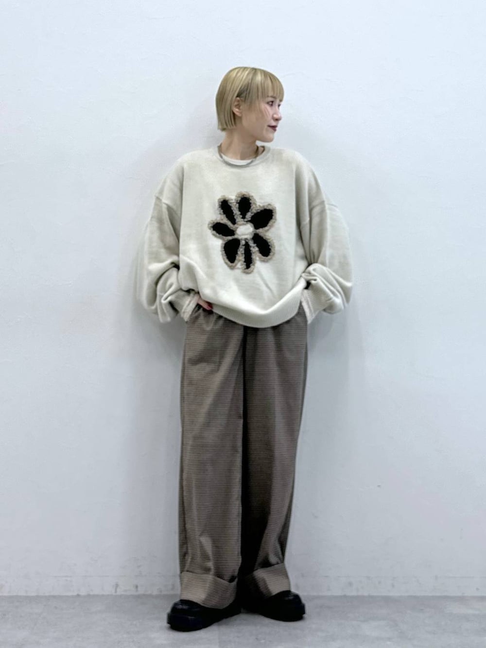 ホワイト系のニット/セーター、ブラック系のローファー、ブラウン系のスラックスを着用したレディースの秋コーディネートの1枚目の写真