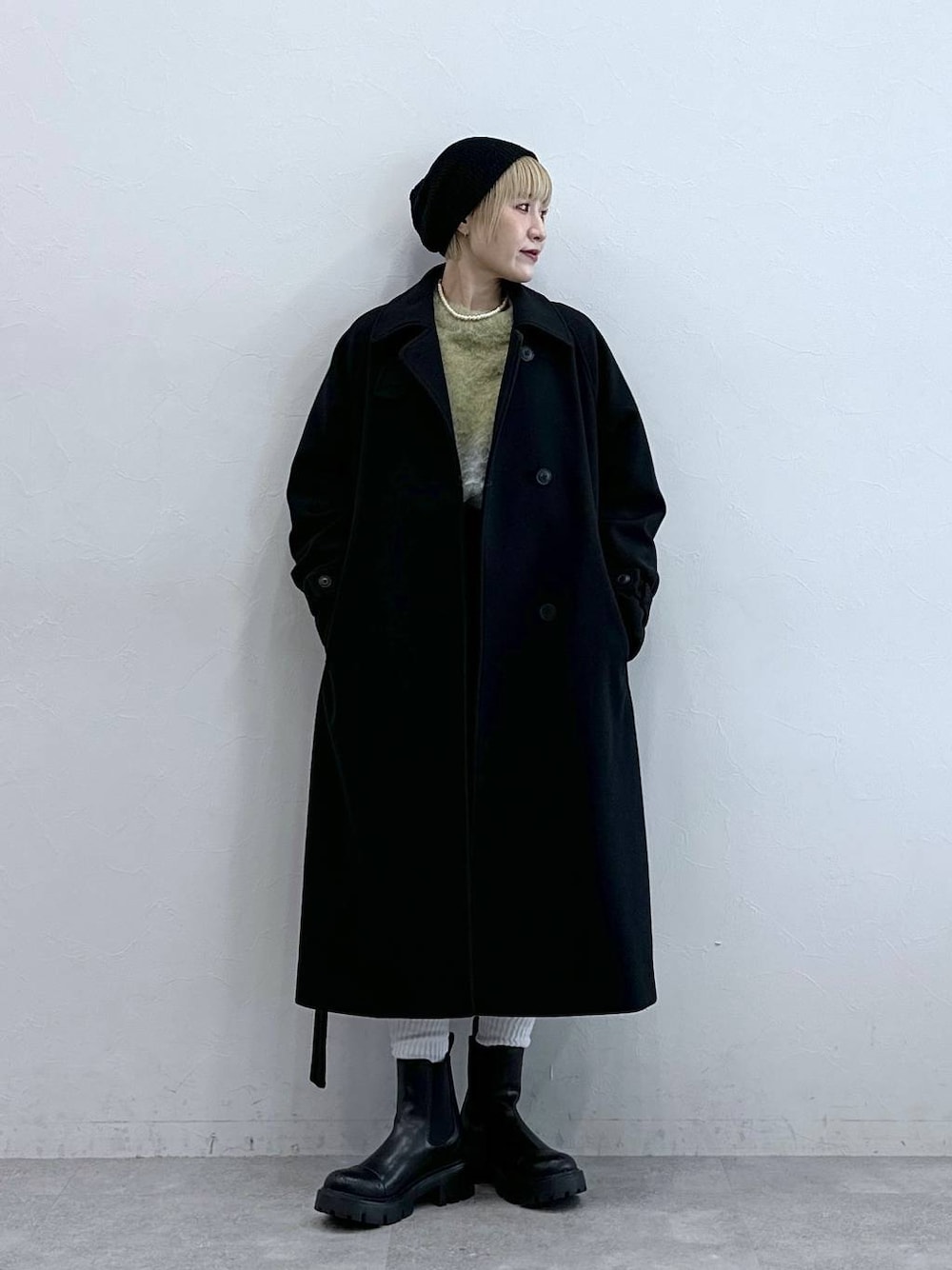 ブラック系のスラックス、イエロー系のニット/セーター、ブラック系のブーツを着用したレディースの秋コーディネートの1枚目の写真