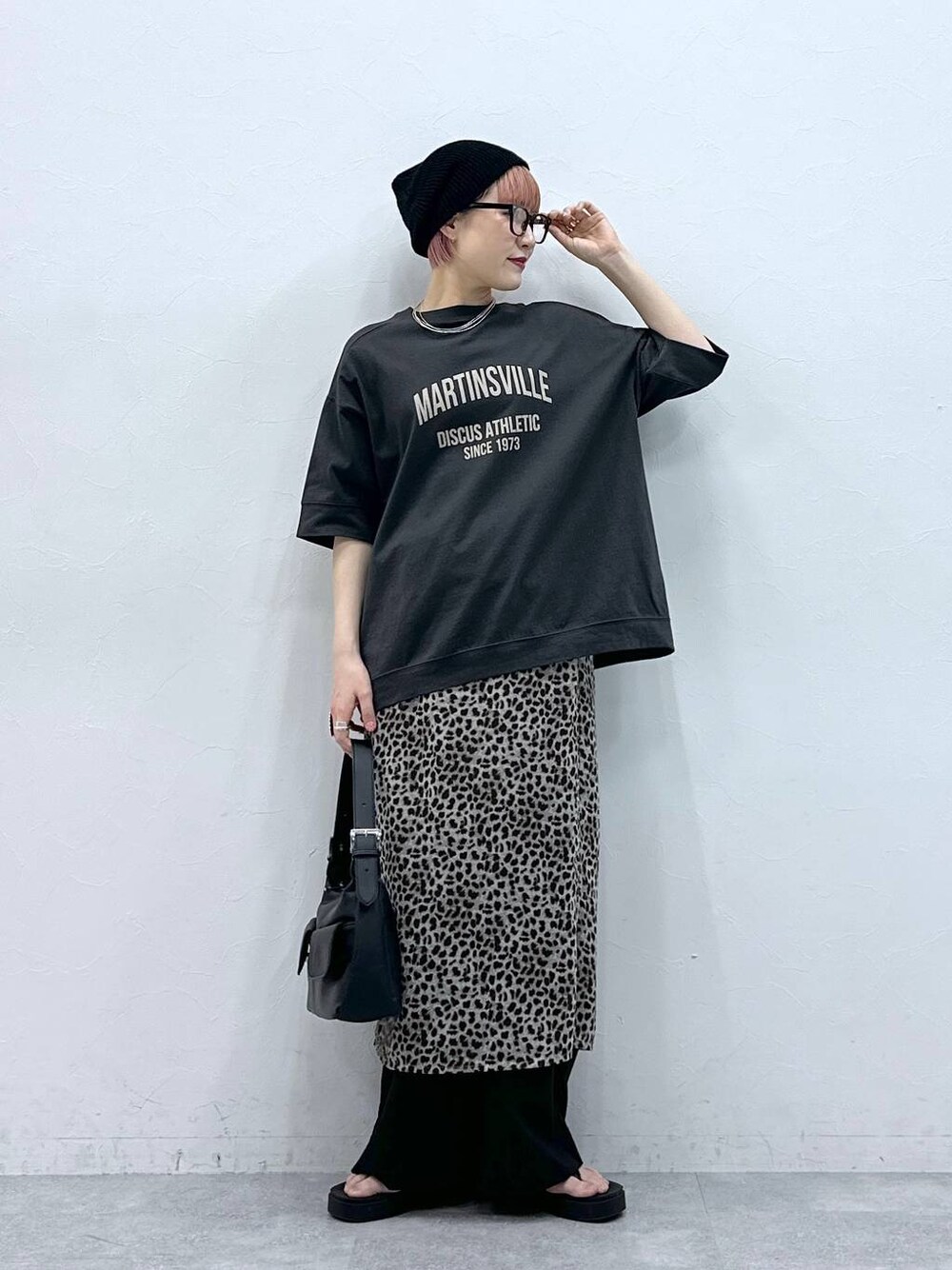 ブラック系のスラックス、グレー系のTシャツ/カットソー、ベージュ系のスカートを着用したレディースの春コーディネートの1枚目の写真