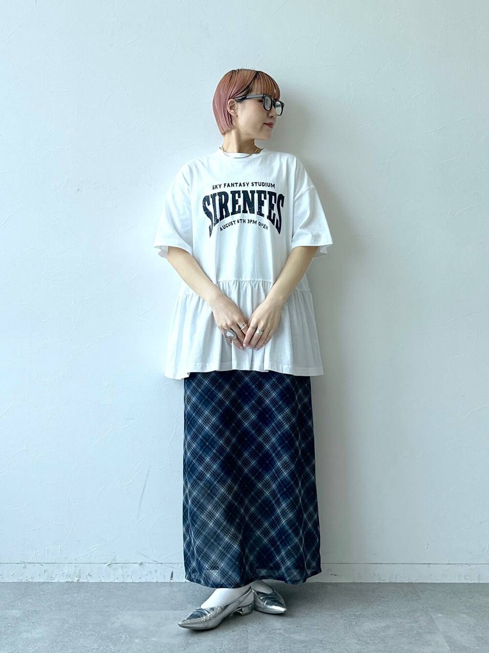 ブルー系のスカート、ホワイト系のTシャツ/カットソー、グレー系のメガネを着用したレディースの春コーディネートの1枚目の写真