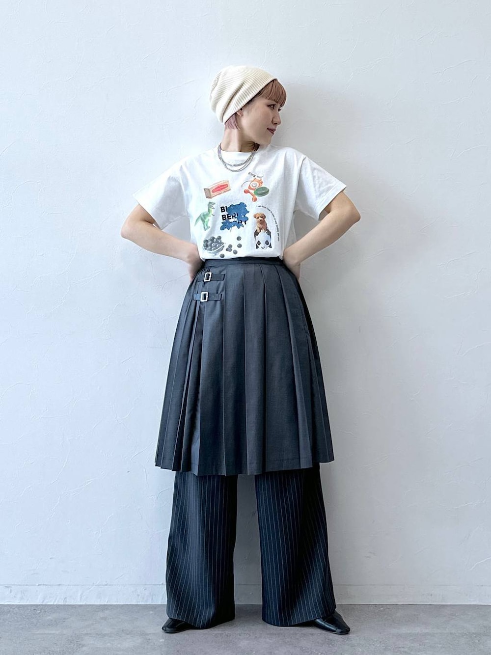グレー系のスラックス、グレー系のスカート、ホワイト系のTシャツ/カットソーを着用したレディースの春コーディネートの1枚目の写真