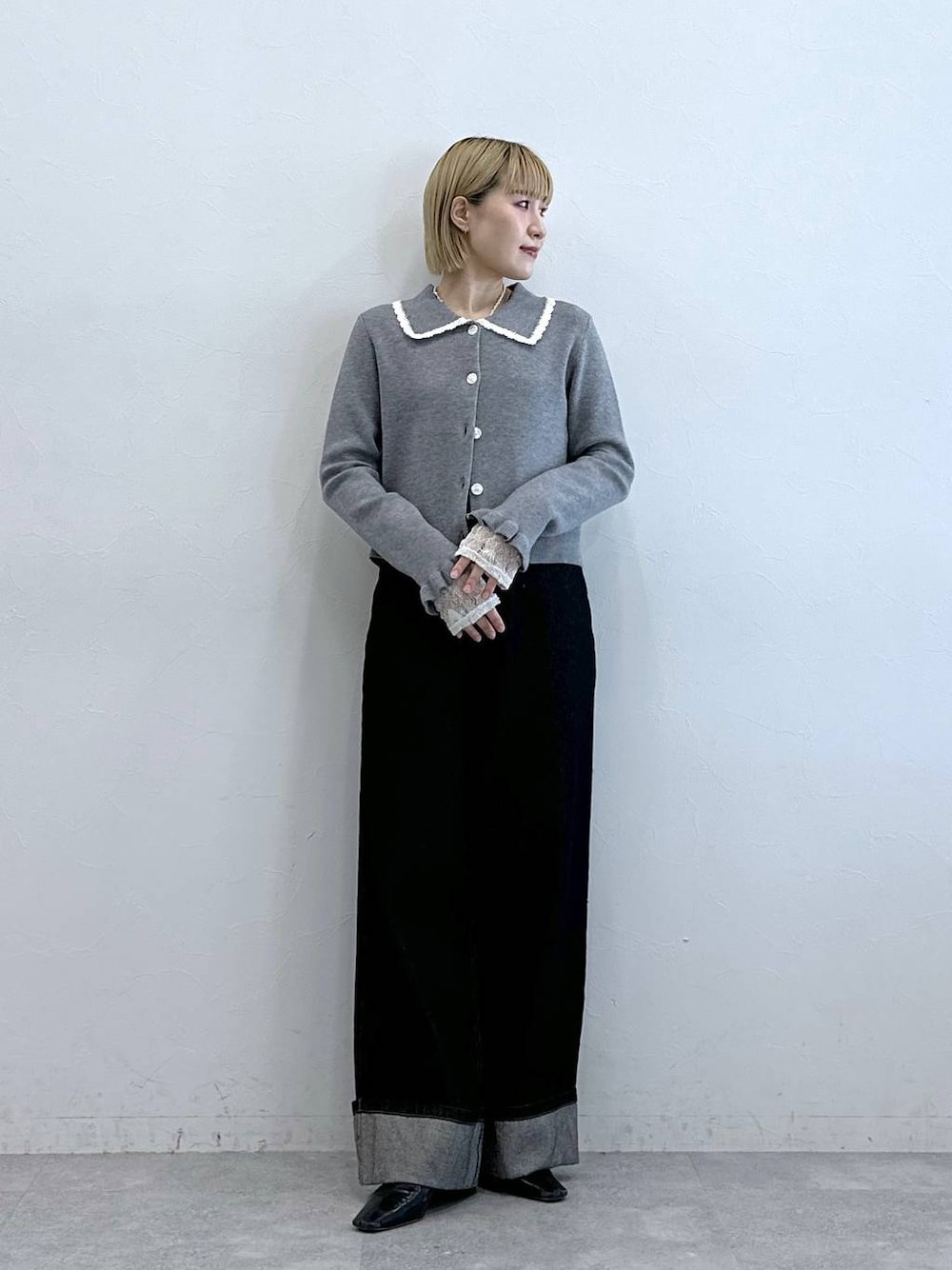 ブラック系のデニムパンツ、ホワイト系のTシャツ/カットソー、グレー系のニット/セーターを着用したレディースの夏コーディネートの1枚目の写真